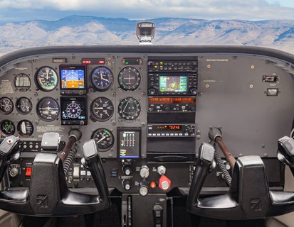 Cessna cockpit and instrument panel with Idaho mountains through the windshield at Carmel Aviation in Boise